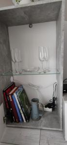 a shelf with wine glasses and books on it at Veronika's House je prijeten, miren apartma v naravi, blizu mesta in Celje