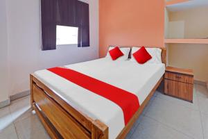 Gulzārbāgh的住宿－Flagship Grand Paradise Inn & Banquet Hall，一间卧室配有一张带红色枕头的大床