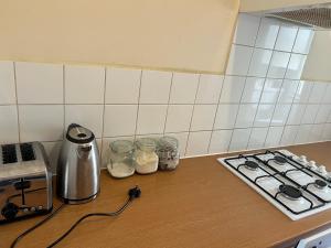 a kitchen counter with a stove and jars of food at Apartament Kings Cross in London