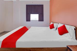 Gulzārbāgh的住宿－Flagship Grand Paradise Inn & Banquet Hall，一间卧室配有红色和白色枕头的床