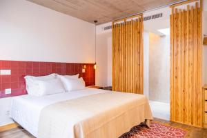 a bedroom with a large white bed and wooden sliding doors at Casa Da Avó Clementina Nº 30 in Funchal