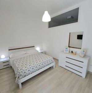 una camera con letto, cassettiera e specchio di Casa Vacanze Argento a Bacoli