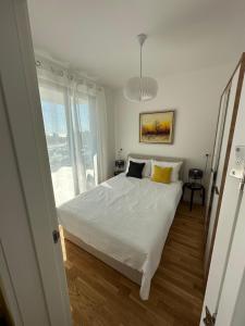 - une chambre avec un lit blanc et une fenêtre dans l'établissement Apartman JaVi, à Bar