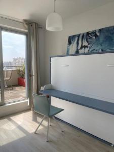 a room with a desk and a chair and a window at Superbe chambre avec terrasse (clim optionnel) in Bagneux