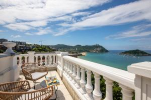 Un balcón con sillas y vistas al océano. en Far Out Inn - Yoga guesthouse, en San Sebastián