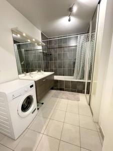 a bathroom with a washing machine and a sink at Superbe chambre avec terrasse (clim optionnel) in Bagneux