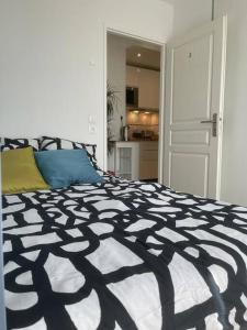 a bedroom with a bed with a black and white comforter at Superbe chambre avec terrasse (clim optionnel) in Bagneux