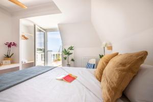 Un dormitorio blanco con una cama grande y una ventana en Far Out Inn - Yoga guesthouse, en San Sebastián