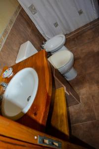 a bathroom with a sink and two toilets in it at cabaña 1 santa catalina in Villa Giardino