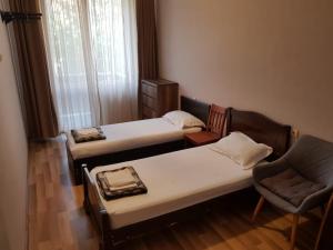 ein Zimmer mit 2 Betten und einem Stuhl darin in der Unterkunft beautiful flat/apartment in Tbilisi City