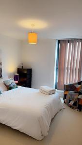 ein Schlafzimmer mit einem großen weißen Bett und einem Fenster in der Unterkunft ComfyCozy Luxury Apartment Canning Town in London