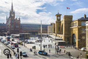 a busy city street with cars and a clock tower at Apartament Kings Cross in London