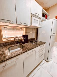 eine Küche mit einer Spüle und einem weißen Kühlschrank in der Unterkunft Amplio loft en zona residencial de Asunción in Asunción