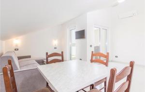 ein Esszimmer mit einem weißen Tisch und Stühlen in der Unterkunft Beautiful Apartment In Funtana With Wifi in Funtana