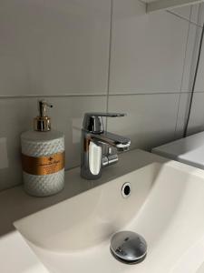 un lavabo blanco con un dispensador de jabón. en Cozy studio in Vantaa, Near Airport with Parking en Vantaa