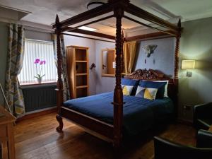 een slaapkamer met een hemelbed en een raam bij Castle Lodge - Brecon Beacons Accommodation in Sennybridge