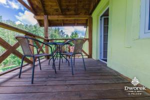 a table and chairs on the porch of a house at Agroturystyka "Dworek u Pelców" in Ryn