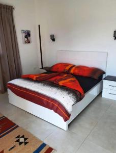 1 dormitorio con 1 cama blanca con sábanas rojas y negras en 7 Jours de Nutrition et Méditation 3-9 novembre 2023 à Luxor, en Luxor