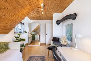 LichtensteinにあるFerienwohnung Kalkauのベッド1台とソファが備わる木製の天井の客室です。