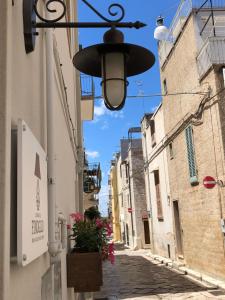 un vicolo con un lampione e fiori in una scatola di Le Dimore del Finoglio a Conversano