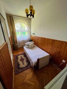 a small bedroom with a bed and a window at Nosztalgia Villa in Mezőkövesd