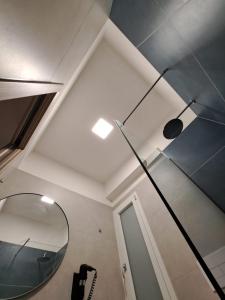 La salle de bains est pourvue d'un miroir et d'un plafond. dans l'établissement Sikelia Superior Rooms Milazzo, à Milazzo