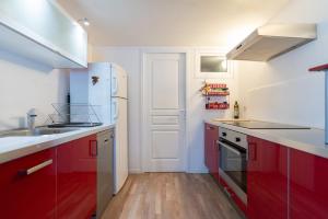 拉格朗德默特的住宿－Grand T2 ensoleillé，厨房配有红色橱柜和白色冰箱