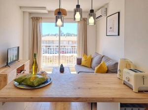 uma sala de estar com uma mesa e um sofá em Charming flat close to the beach em Canet de Berenguer