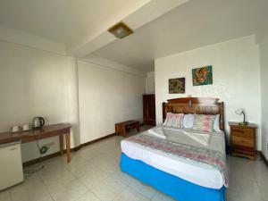 ein Schlafzimmer mit einem Bett in einem Zimmer in der Unterkunft Camiguin Island Golden Sunset Beach Club in Mambajao
