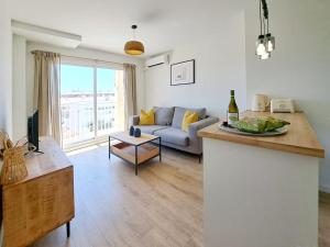 ein Wohnzimmer mit einem Sofa und einem Tisch in der Unterkunft Charming flat close to the beach in Canet d'en Berenguer