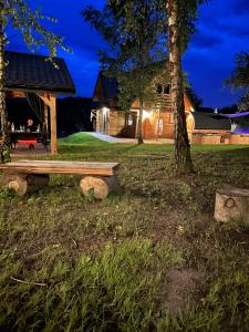 a park bench in front of a house at night at GRABNIK55 in Krasnobród
