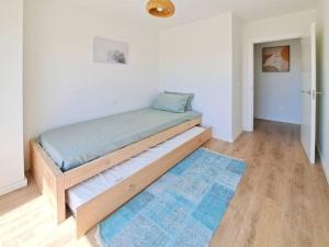 Bett in einem Zimmer mit blauem Teppich in der Unterkunft Charming flat close to the beach in Canet d'en Berenguer