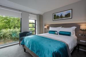 a bedroom with a large bed and a large window at Greenlands Hotel in Henley on Thames