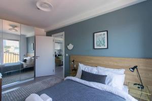 een slaapkamer met een bed met een blauwe muur bij Warm Bright 2BR Urban Home w/ Free Shuttle+Parking #127 in Istanbul