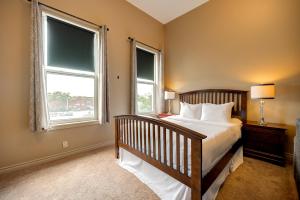 a bedroom with a large bed and two windows at Wellington Street Inn by Hoco Hotels Collection in Stratford