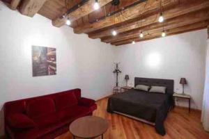 a living room with a bed and a red couch at Angels Roof - Betlemi. Garden & View over Old Tbilisi in Tbilisi City