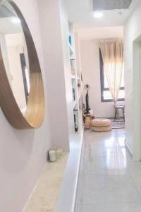 a white hallway with a mirror on the wall at One bedroom Machane Yehuda Design Apartment in Jerusalem