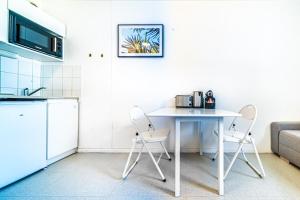 a kitchen with a white table and two chairs at Le petit Chinard- studio cosy-Vaise in Lyon