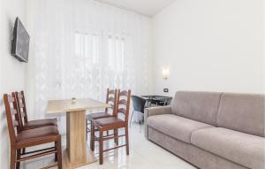 een woonkamer met een bank en een tafel en stoelen bij Stunning Apartment In Funtana With Wifi in Funtana