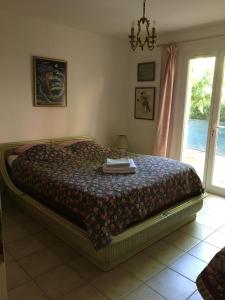 een slaapkamer met een bed met een quilt bij Villa clochette in Les Arcs sur Argens
