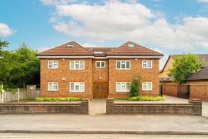 een groot bakstenen huis met een oprit bij Kempton Park Views -Two Double Bedroom Luxury Apartments in Sunbury Common