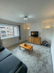 a living room with a couch and a flat screen tv at 4 Bedroom Flat In Watford in Leavesden Green