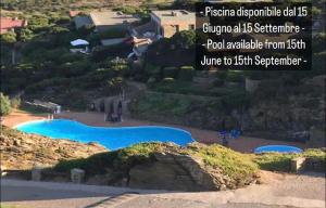 una foto de una piscina en la cima de una colina en Panoramic villa on top of Capo Falcone en Stintino