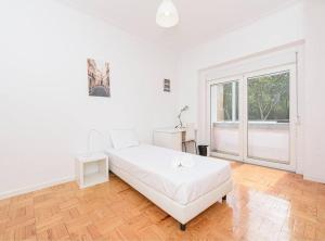 a white bedroom with a bed and a large window at HOUZE_4 room flat in Central Lisbon near Zoo in Lisbon