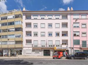 un gran edificio con coches estacionados frente a él en HOUZE_4 room flat in Central Lisbon near Zoo, en Lisboa