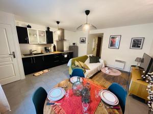 a kitchen and a living room with a table and chairs at Doyen 1 Proche centre ville in Reims