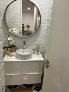 a bathroom with a sink and a mirror at Porto Apartamento relaxante na cidade in Porto