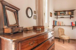 a dresser with a mirror and a chair in a room at Appartamento Lungolago in Domaso