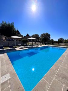 duży basen z niebieską wodą w obiekcie Hôtel Les Vieilles Tours Rocamadour w mieście Rocamadour