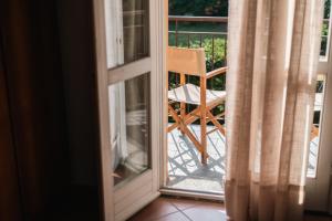 an open door with a chair on a balcony at Appartamento Lungolago in Domaso